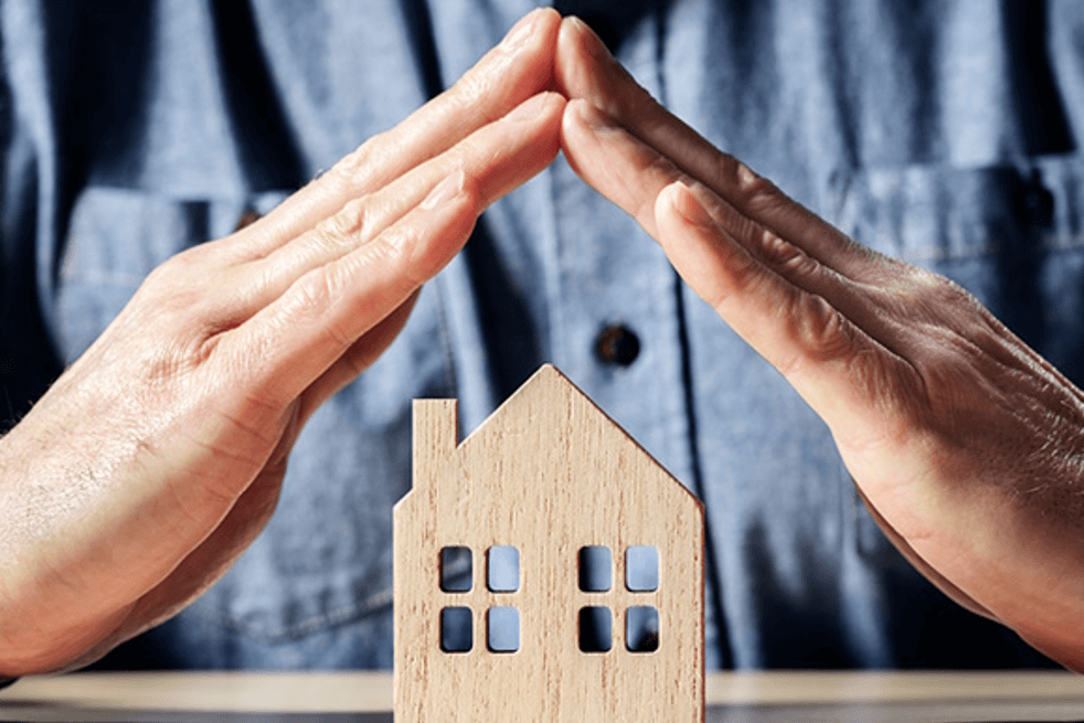 hands protecting a house