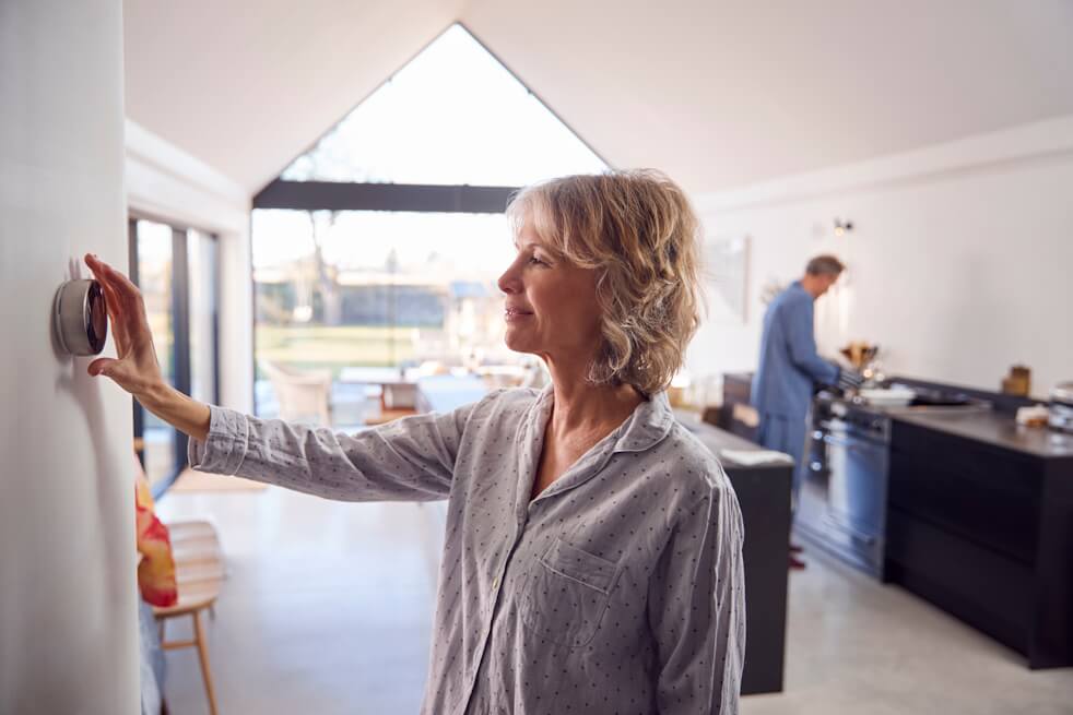 woman adjusting thermostat