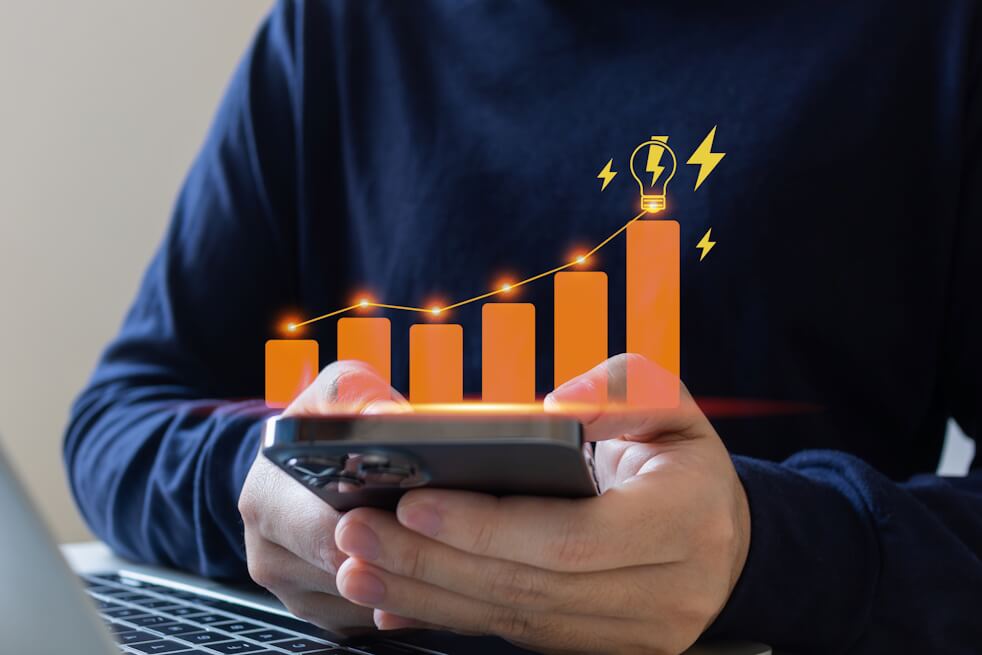 man reviewing increased energy bill on phone