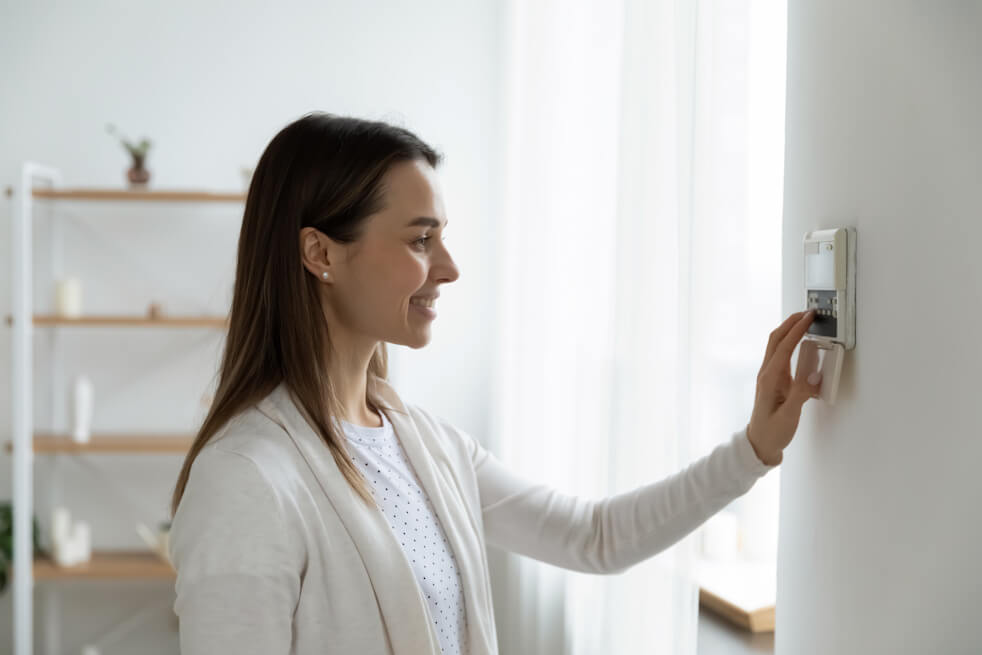 woman adjusting thermostat