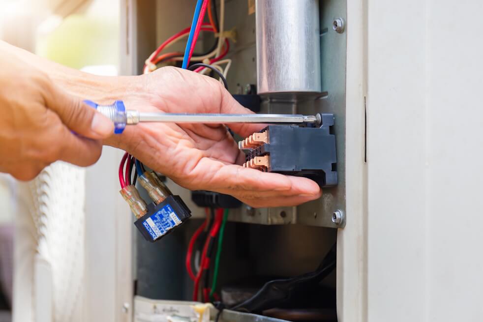 close up of electrician working on hvac unit